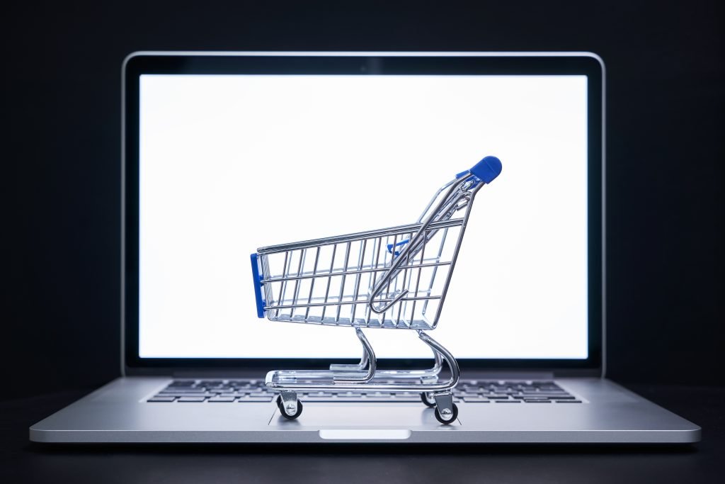 Close-up of shopping cart on laptop against black background